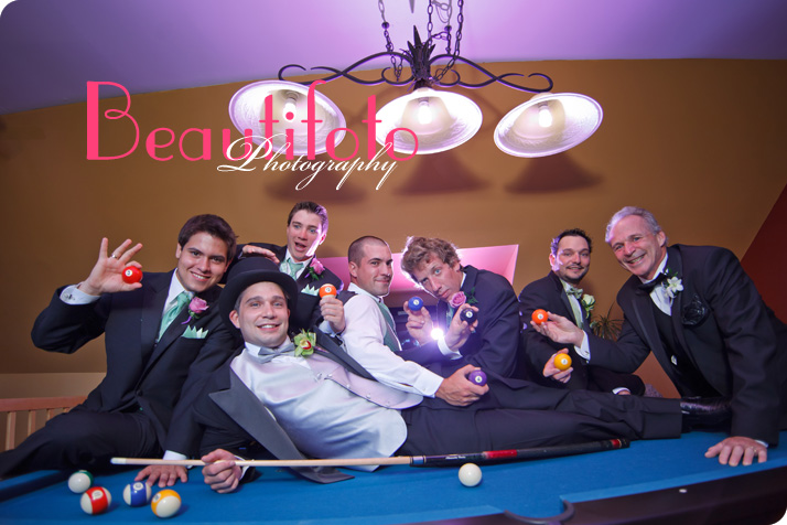 The groom lying on a pool table with the groom
