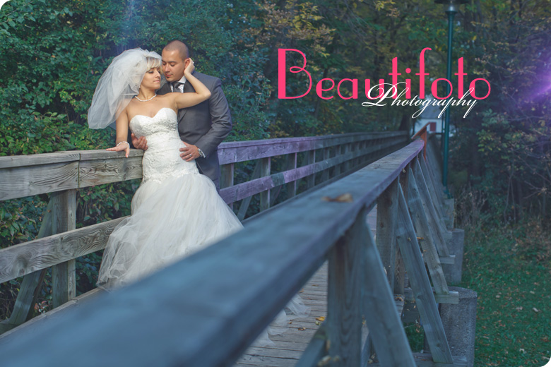 Bride and groom embrace on an old bridge. Photo by Beautifoto Montreal wedding photographer.
