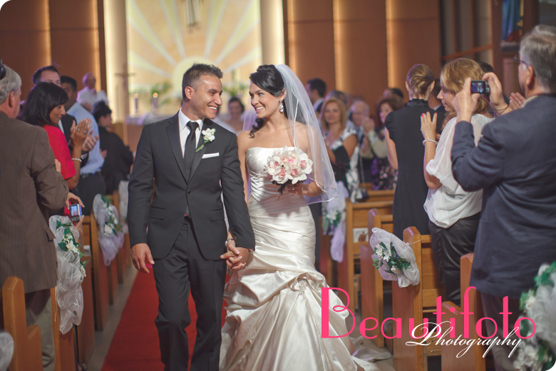 Bride and Groom walking down the isle at Maria Ausiliatrice church.