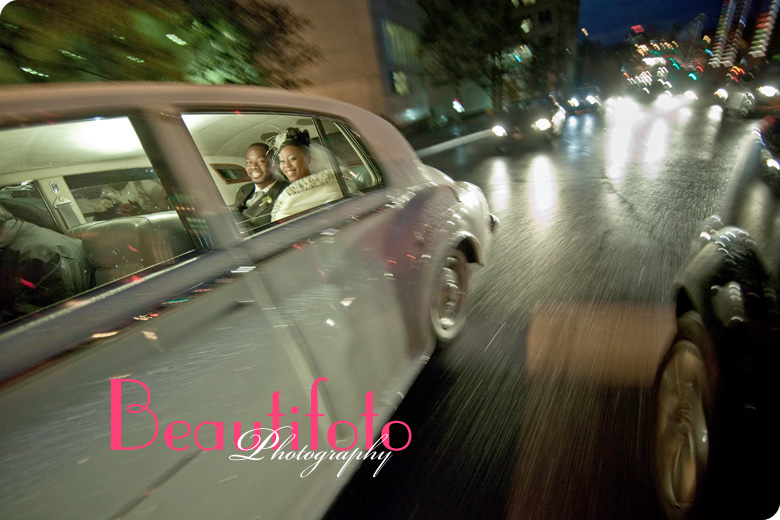 The bride and groom on the way to the reception in their limosine