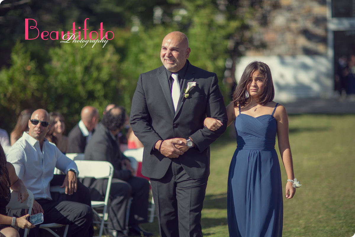 An emotional groom and his daughter walking down the aisle