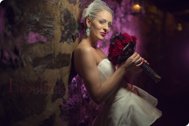 Beautifoto Montreal wedding Photographer shoot a bride holding her flower bouquet as she leans against a stone wall at the Old Port of Montreal
