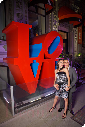 the couple posing next to the love sign in front of the L hotel in Montreal's old port
