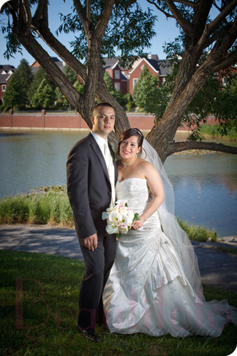 the bride and groom posing by a tree in bois franc
