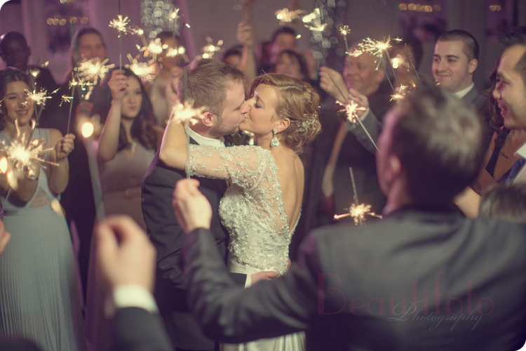 the bride and groom's first dance with their guests holding sparklers all a round them at Le Crystal reception hall