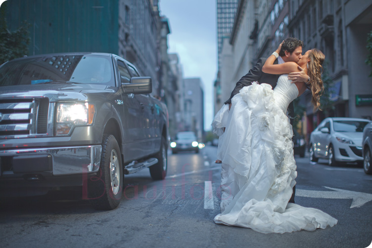 Bride and groom kissing in the streets of Old Montreal. Photographer: Beautifoto