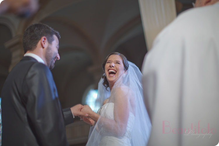 Bride laughs as the groom tries to fit the ring on her finger while they were exchanging vows.